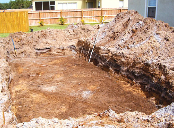 Backyard after a hole was dug where a fiberglass pool will be installed