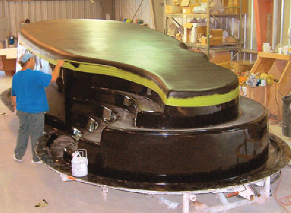 Upside down view of a fiberglass pool shell during manufacturing